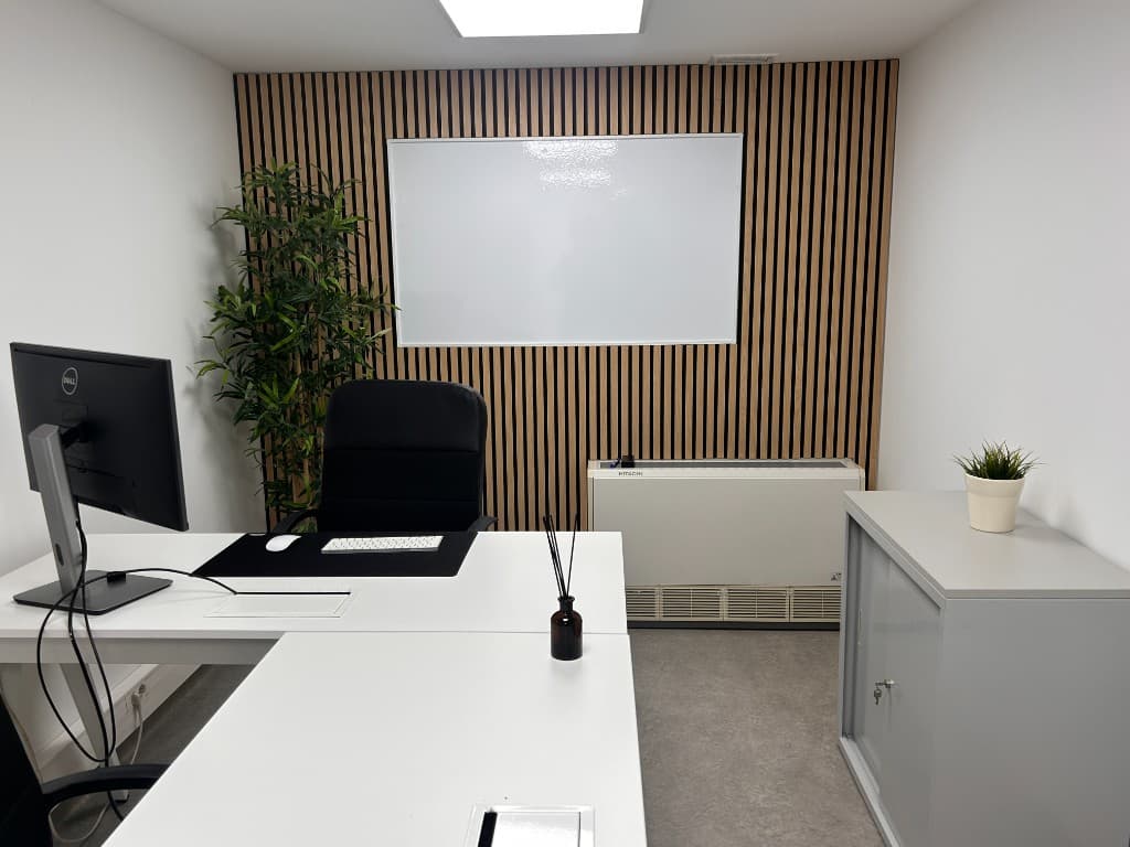 Escritório privado no Cowork Malvarosa, secretária, monitor e quadro branco num espaço fechado