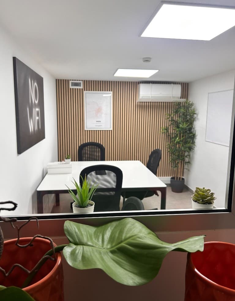 Escritório privado visto através do vidro, secretária branca, cadeiras e quadro branco